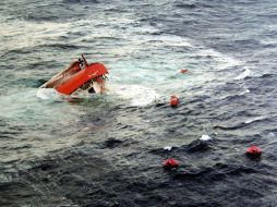 Una precaria embarcación naufraga en el mar frente a Libia, el martes pasado. ARCHIVO /