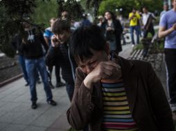 Una mujer reacciona, tras presenciar el enfrentamiento de los guardias ucranianos contra una multitud. AP /