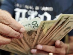 El billete verde en 13.25 pesos en la capital del país. ARCHIVO /