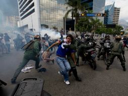 Guardias nacionales lanzan gases lacrimógenos y detienen a manifestantes en la capital venezolana. AP /