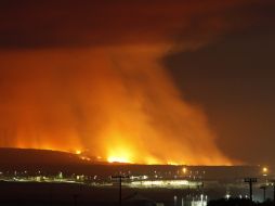 Escuadrillas de bomberos buscan contener las flamas que han causada al menos una muerte. AFP /