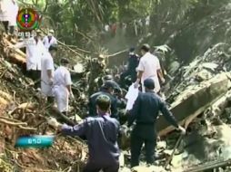 Esta imagen tomada de un video de la Lao National TV muestra a rescatistas en el lugar donde se estrelló el avión. AP /