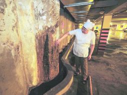 Doña Margarita, presidenta de locatarios del Mercado Mexicaltzingo, muestra el escurrimiento en un sótano del inmueble.  /