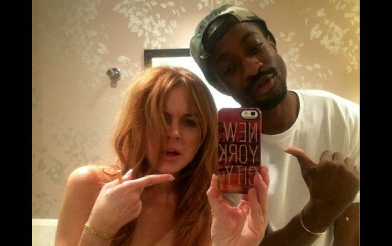 En la foto, Lohan aparece con el maquillaje corrido, despeinada y acompañada de un amigo. ESPECIAL /