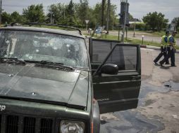 La policía ucraniana observa un coche con restos de balazos tras la dura batalla entre los soldados prorrusos y armada ucraniana. EFE /
