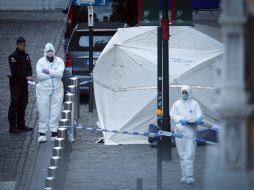 Los agentes de policía y los investigadores trabajan en la zona acordonada cerca del Museo Judío. AFP /