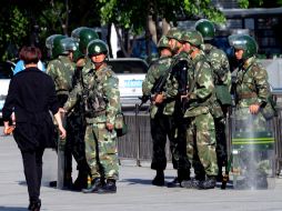 Policías chinos montan guardia, después de los atentados que dejaron varios muertos en un mercado Urumqui. AFP /