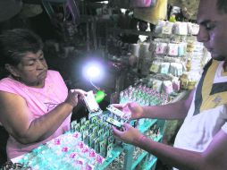 La falta de electricidad hace que los comerciantes tengan que valerse con lo que puedan para iluminar y mostrar sus productos.  /