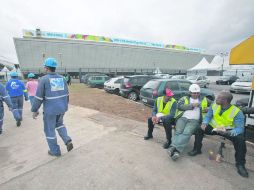 Constructores toman un descanso, ayer, durante las obras para concluir la sede del partido inaugural. EFE /
