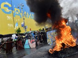 Los manifestantes incendian neumáticos en protesta por el llamado de las autoridades a que levanten su campamento. AFP /