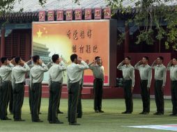 Policías paramilitares practican sus saludos en la entrada de la plaza de Tiananmen. AP /