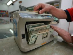 El tipo de cambio para solventar obligaciones en moneda extranjera pagaderas en el país es de 12.8868 pesos. ARCHIVO /