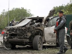 Autoridades afganos inspeccionan uno de los vehículos que colisionó y explotó contra la convoy de Abdulá. EFE /