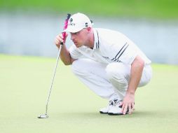 Al acecho. Ben Crane ajusta su tiro en el green del hoyo 18. AFP /
