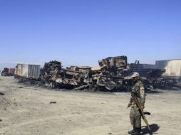 Un soldado afgano camina junto a tanques y camiones en mal estado por bombardeos. ARCHIVO /