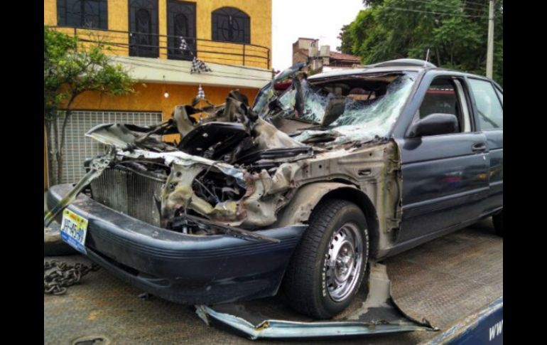 El Nissan Tsuru azul, con placas JHF-4599, se estrella en la parte posterior de un camión. El chofer del camión es detenido.  /