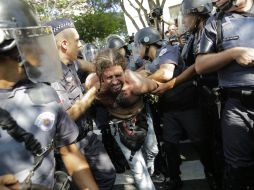 La policía detuvo a uno de los manifestantes que intentó frenar la marcha de los elementos. AP /