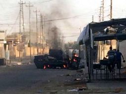 Vista de dos vehículos policiales incendiados en una calle de Tikrit, norte de Iraq. EFE /