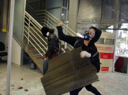 Encapuchados lanzan piedras a los autos y comercios de la ciudad de Salvador de Bahía. EFE /