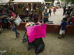 Cada sábado, mujeres cargadas con bolsas negras y letreros llegan al Parque Rojo para intercambiar sus pertenencias.  /