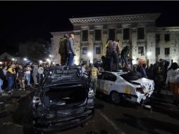 Manifestantes volcaron los coches que estaban estacionados frente a la embajada rusa. AFP /