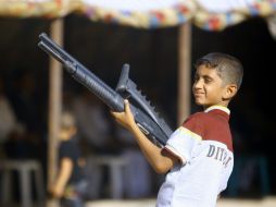 Un niño sostiene un arma, forma parte del grupo de yihadistas que invade el norte de Iraq. AFP /