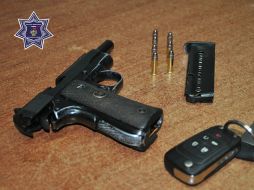 Autoridades presentan un arma y llaves de un automóvil robado.  /