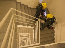 El cuerpo de bomberos desaloja el edificio para continuar con la limpieza del fuego. ARCHIVO /