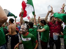 Aficionados celebran en la Minerva el triunfo del Tri. AFP /