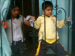 Las fotos que circulan en redes sociales muestran al infante amarrado a los barrotes de protección de la ventana de su casa. ESPECIAL /