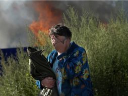 Una mujer llora cerca de una casa incendiada, luego de un bombardeo en la ciudad de Slaviansk. AP /