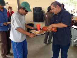Aspecto de un comedor y dispensario médico, en la imagen una persona sirve comida a un migrante. NTX /