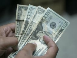 El tipo de cambio para solventar obligaciones en moneda extranjera pagaderas en el país es de 12.9768 pesos. ARCHIVO /