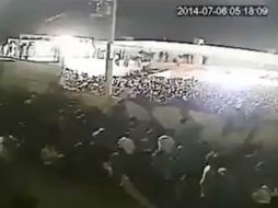 La grabación difundida en internet, captada por una cámara de vigilancia, muestra a la gente aproximarse hacia una barda. ESPECIAL /