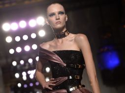 Metales y vestidos muy pegados al cuerpo con superpuestos en seda y organza, desfilaron ante los presentes. AFP /