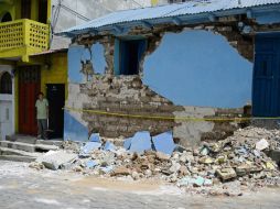 Un hombre permanece a las afueras de su vivienda dañada por el temblor. AFP /