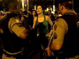 Policías realizan detenciones en el FanFest donde aficionados veían el partido entre Brasil y Alemania. AP /