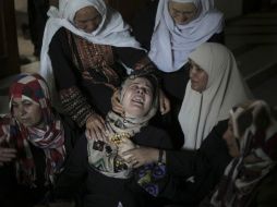 Mujeres palestinas lamentan la muerte de algunos familiares luego de un ataque aéreo israelí. AP /
