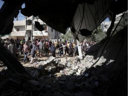 Palestinos observan una casa destruida tras ataque bombarderos. AP /