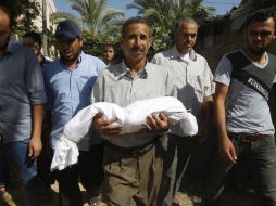 Un padre palestino carga el cuerpo de su hijo. Según fuentes médicas, un 70 por ciento de los 81 fallecidos son civiles. AFP /