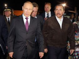 El presidente de Nicaragua, Manuel Ortega, acompaña a Vladimir Putin a su aeronave, donde partirá rumbo a Argentina. EFE /