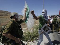 Palestinos se enfrentan soldados israelíes, durante una manifestación en contra de la acción militar israelí en Gaza. AP /