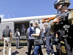 Inspectores y forenses de la OSCE revisan los cuerpos en una estación de tren cerca de Donetsk. EFE /
