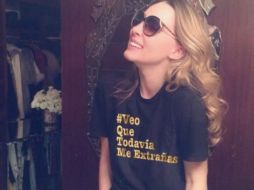 En la imagen, aparece sonriente y portando una playera que dice '#veoquetodaviameextrañas'. ESPECIAL /