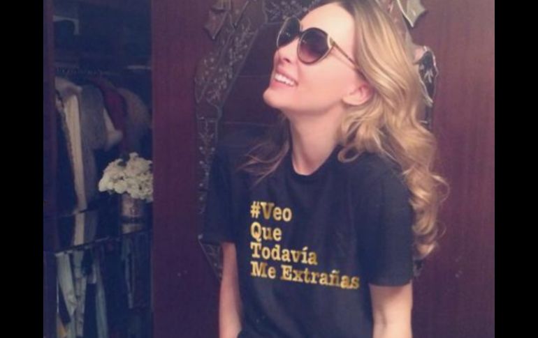 En la imagen, aparece sonriente y portando una playera que dice '#veoquetodaviameextrañas'. ESPECIAL /