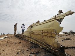 Un soldado francés y un periodista observan los restos del vuelo que se estrelló en Mali y que no dejó sobrevivientes. AFP /