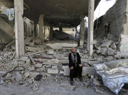 Una mujer palestina llora en los restos de su casa que fue destruida por los ataques israelíes. AP /