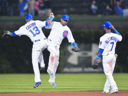 Starlin Castro (número 13), Emilio Bonifacio (número 64) y Arismendy Alcantara (número 7) celebran la victoria sobre los Rockies. AFP /
