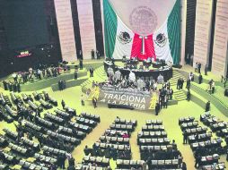 Mientras el dictamen era votado, los perredistas desplegaron una lona en la que llamaban traidores a priistas, panistas y pvemistas. SUN /