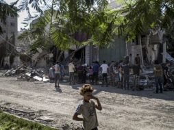 Un niño palestino se cubre sus ojos del polvo luego de un derrumbe ocasionado por un bombardeo israelí. AFP /